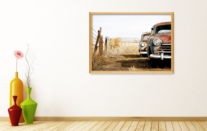FSC wood frame 5002 in light brown colour, with poster of abandoned old cars, placed in interior of natural colors with vases. Picture frame producer Debex Suisse.