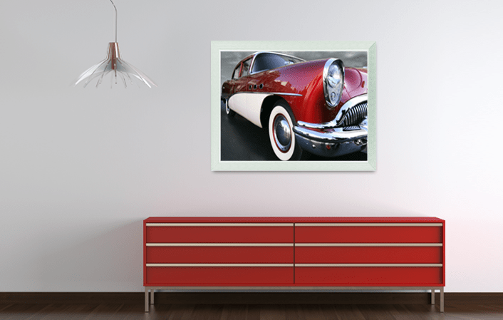Aluminium Gallery Frame 8780 in silver matt colour, with picture of old timer car, placed in interior with red cupboard and a lamp. Picture frame producer Debex Suisse AG.