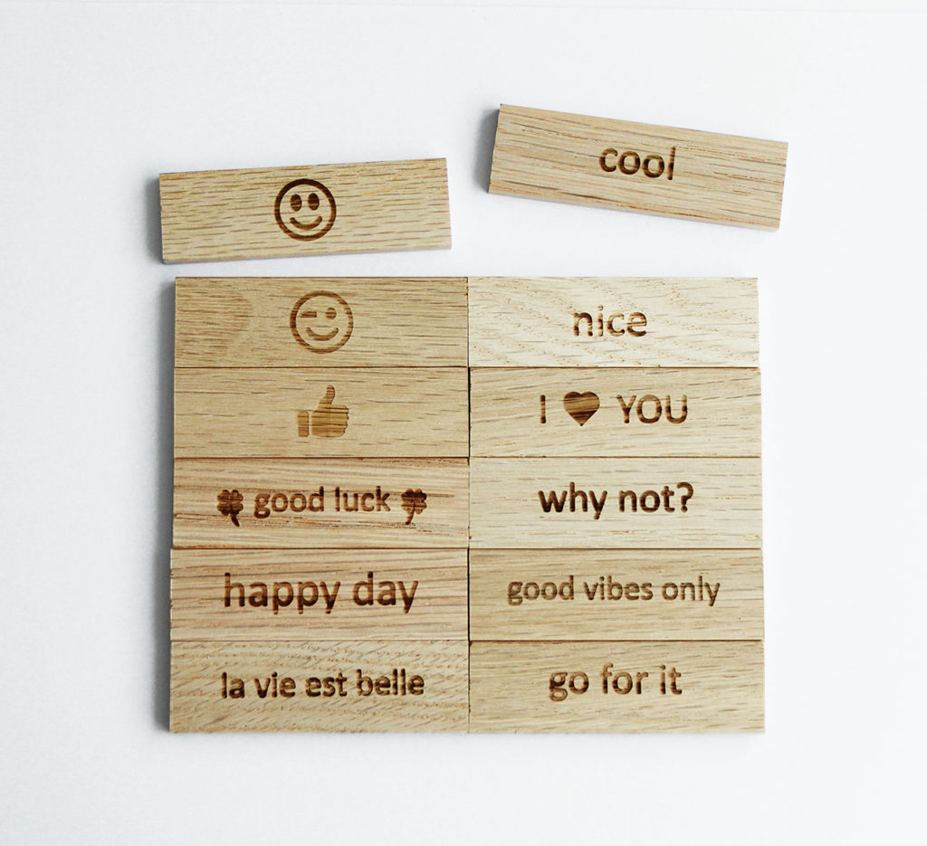 Engraved wooden blocks with positive messages and emojis